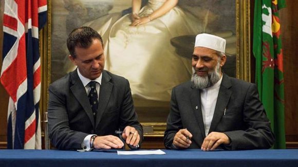 Mark Lancaster, Minister for Defence Veterans, Reserves and Personnel counter signs the Armed Forces Covenant with Dr Musharraf Hussain Chief Imam.