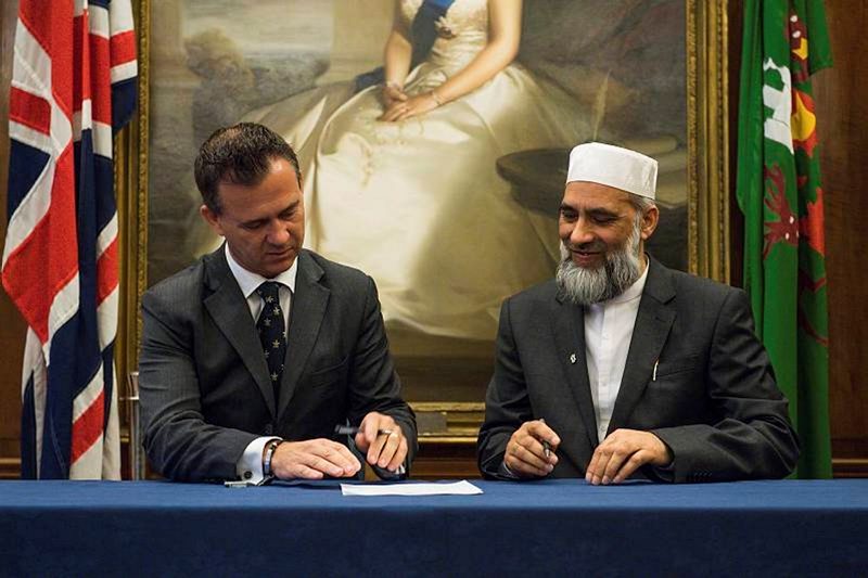 Mark Lancaster, Minister for Defence Veterans, Reserves and Personnel counter signs the Armed Forces Covenant with Dr Musharraf Hussain Chief Imam.