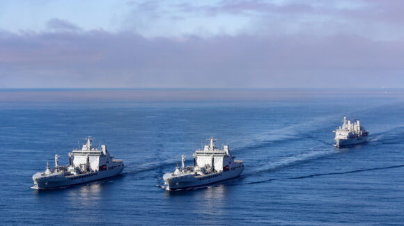 A Royal Navy Merlin Mk2, from 814 NAS, conducted a photographic exercise (PHOTEX) involving RFA Tideforce (A139) (left) and RFA Tidesurge (A138) (right), with RFA Fort Victoria (A387) (rear) off the Southwest Coast.